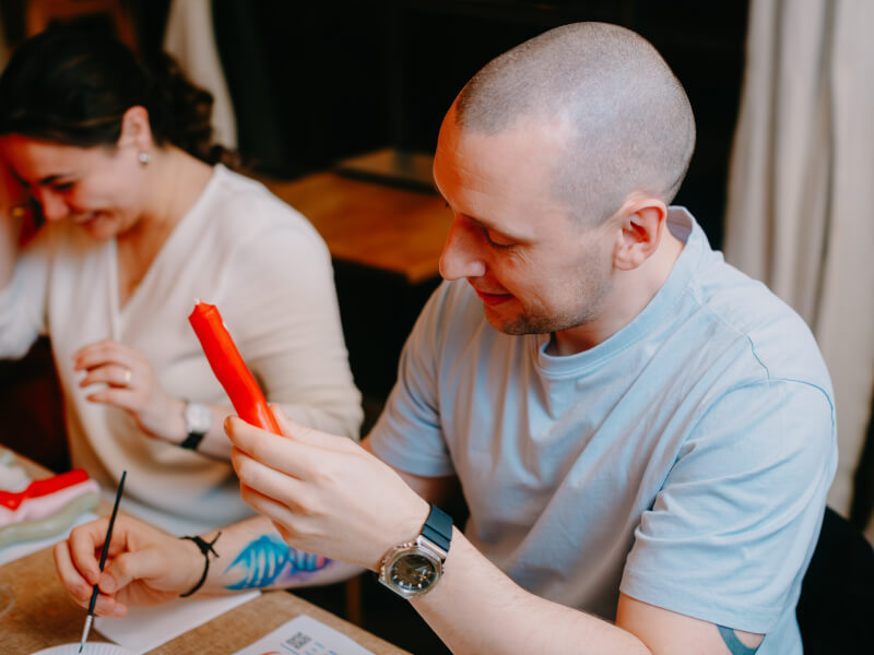A group of people at a candle painting class